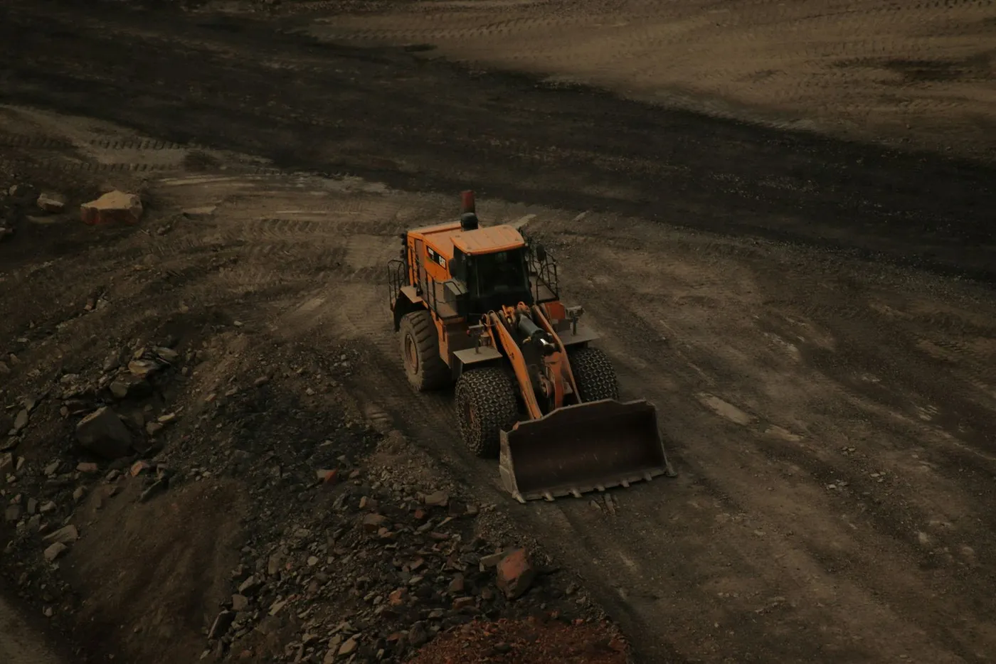 Bulldozer working a dirt road from above