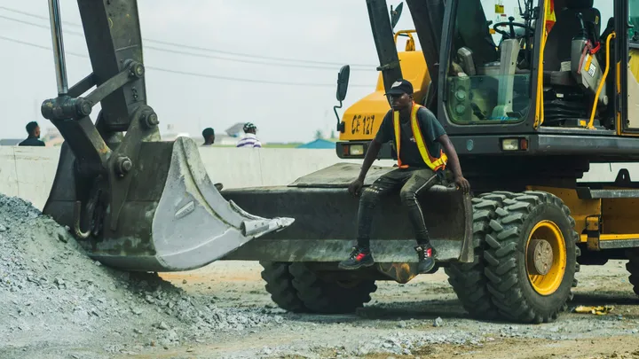 Operator sitting on a wheeled excavator bucket