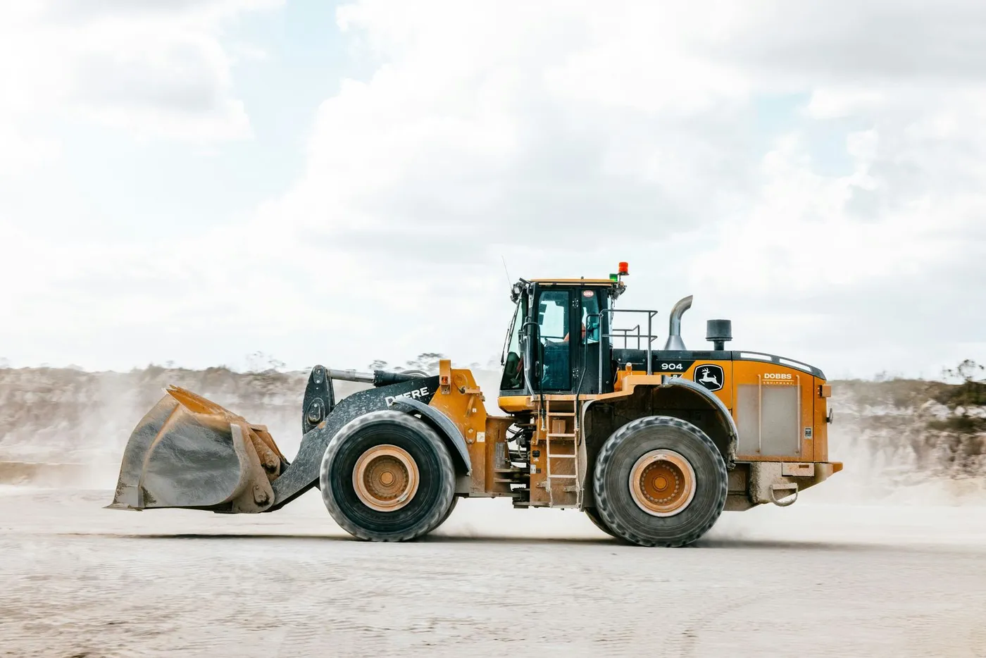 Wheel loader crossing a dusty yard