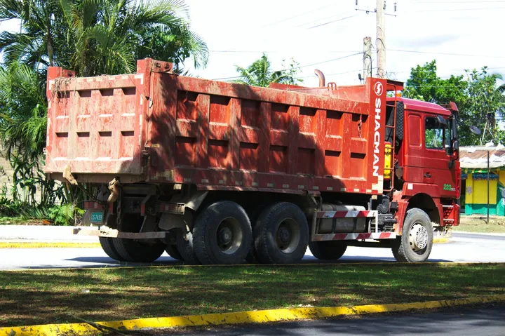Red 6-wheel tipper parked on a roadside